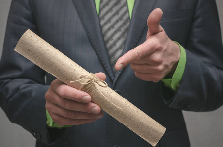 项目宪章前方标志商人手里拿着一卷文件卷轴. 签署协议.