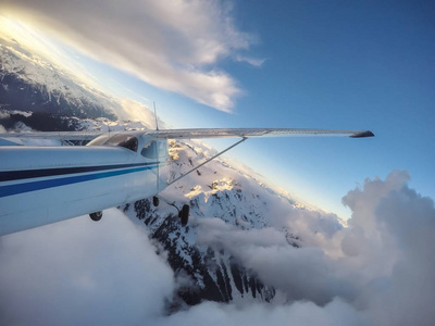 小飞机飞越加拿大山区景观在一个充满活力的日落。 靠近温哥华不列颠哥伦比亚省北部的斯卡米什。