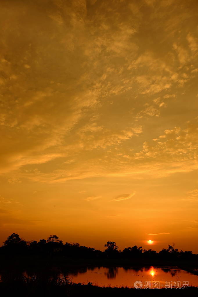 夕阳下五彩缤纷的天空日出在乡下橙色的云在晚上反射阳光