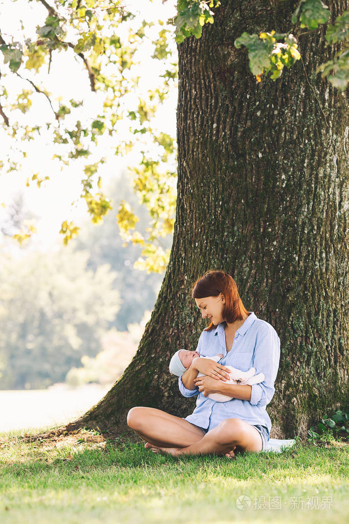 慈爱的母亲与她的新生婴孩在她的胳膊