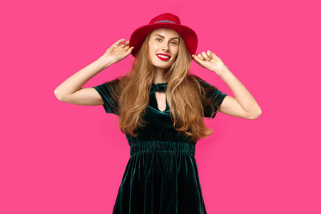 年轻美丽的女人在粉红色的背景穿着绿色的礼服和帽子。健康营养和体育的概念。色彩痴迷的概念。简约风格。时尚时尚