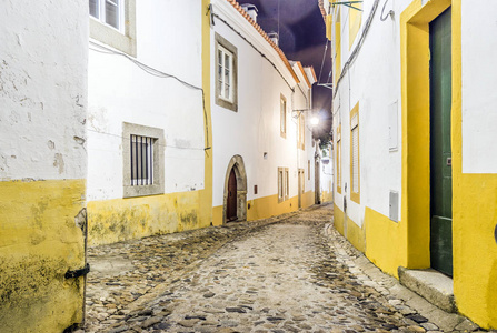 狭窄的街道与白色和黄色房子在埃武拉, Alentejo, P