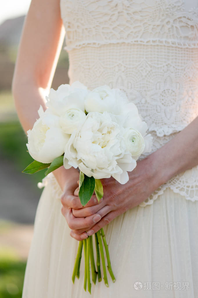 新娘花束新娘捧着一束牡丹花美丽的白牡丹