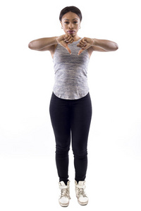 黑色女性，穿着白色背景的运动服，拇指朝下，是一名健身教练