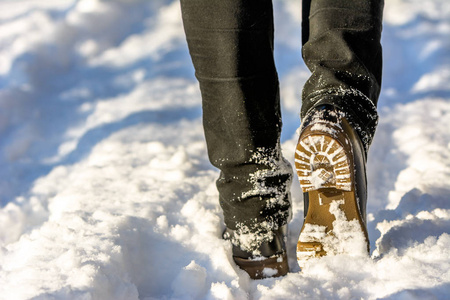 穿着雪靴走路的女人穿着牛仔裤的脚和腿穿着冬天的女人鞋