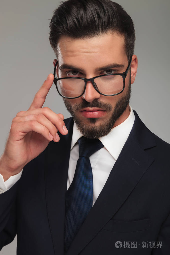 精明的商人把手指放在眼镜上思考