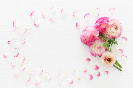 细腻柔和的粉红色美丽的花朵布置在白色的木质背景。平躺, 顶部视图