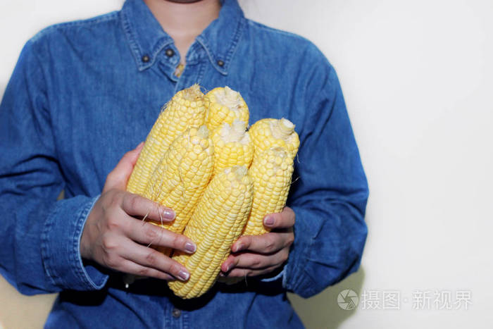 女人手里拿着玉米棒