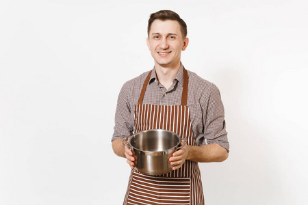 男子厨师在条纹棕色围裙持有银色的不锈钢光泽铝空 stewpan, 平底锅或锅在白色背景下隔离。男管家或 houseworker。