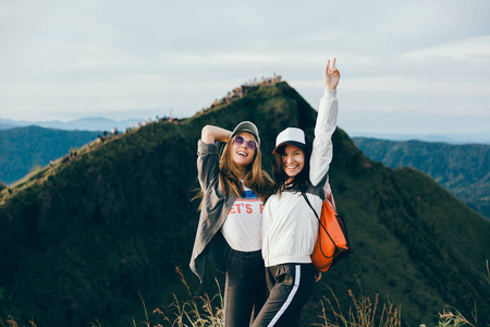 女旅行者看着林贾尼火山岛伦博克。 年轻的背包客沿着山区旅行快乐的女性散步发现世界暑假概念手中的赢家巴厘岛