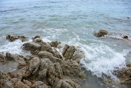 美丽的海滩，白色的波浪，岩石和白色的沙滩，渔船，微风，阳光在明亮的日子。美丽的海滩，清澈的水，美丽的海滩和海浪。 在阳光明媚的一