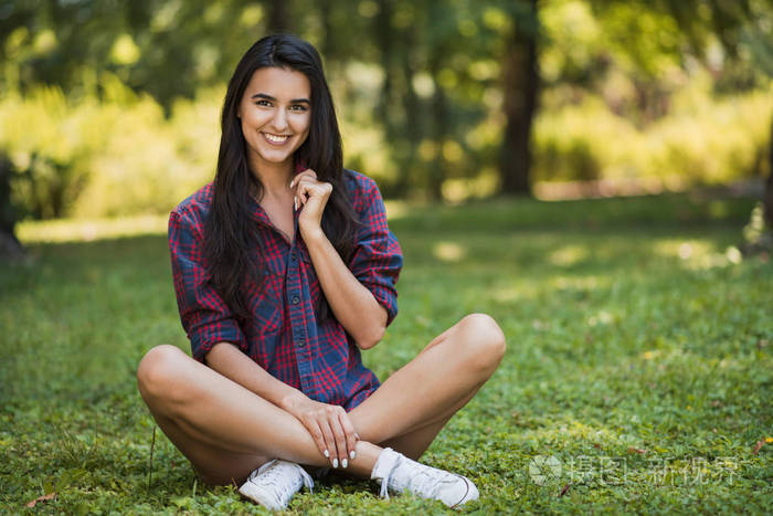 迷人的全身体拍摄的快乐的年轻黑发白种女性微笑着穿着格子衬衫的选址