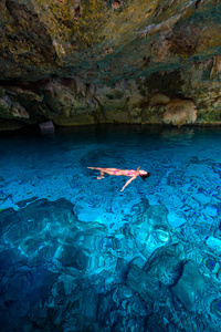 墨西哥昆塔纳罗奥的Cenote DosOjos。 人们在清澈的蓝色水中游泳和浮潜。 这个塞诺特位于墨西哥尤卡坦半岛的图卢姆附近。
