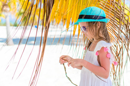 大椰子在沙滩上快乐的小女孩