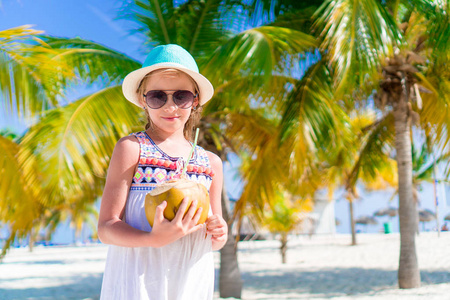 大椰子在沙滩上快乐的小女孩照片