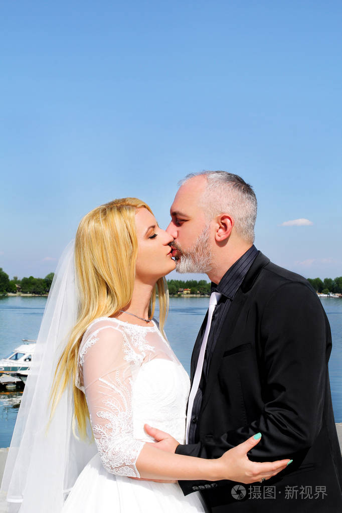 婚礼的概念幸福英俊的新婚夫妇站在那里接吻浪漫的新郎和新娘的爱拥抱