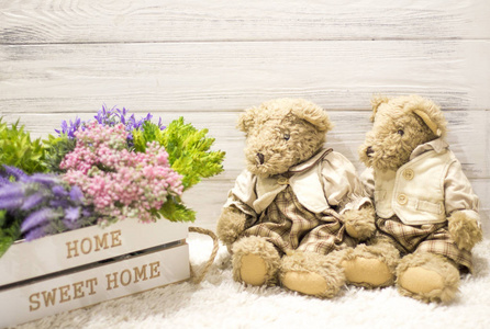 木箱里的花和可爱的毛绒熊。 浪漫的礼物。