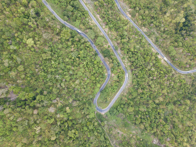 上面的风景。 无人机的鸟瞰。 皇室高质量的自由库存形象的道路在森林。 森林中的道路是美丽的，有许多树，道路经过非常曲折和弯曲