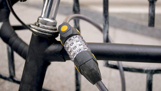 特写镜头照片的组合锁在老老式自行车锁到金属栅栏