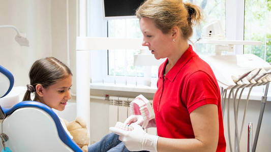 女牙医与她的病人谈论牙齿卫生的肖像