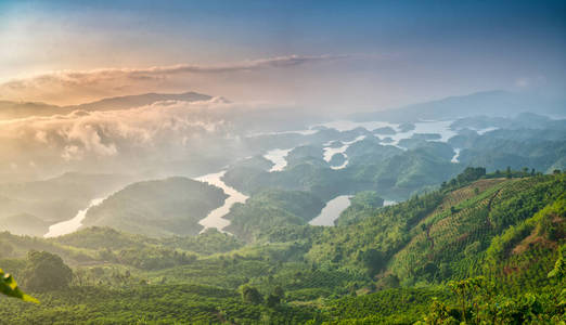 早上，当太阳升起在山顶时，塔粪湖把雾照进充满雾的湖和小岛屿天堂。 这是越南达克农水电水库。