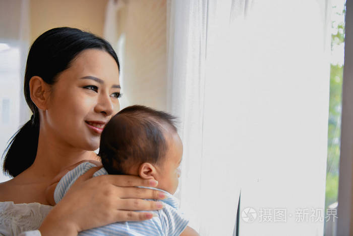 新生概念。母亲和孩子在一张白色的床上。妈妈和宝宝 b