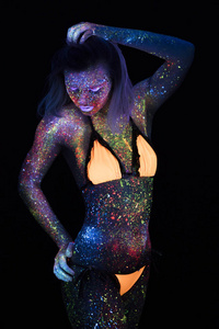 美丽的时尚女人在霓虹灯超滤光的肖像。模型女孩与荧光创意迷幻化妆, 艺术设计的女性迪斯科舞蹈模特在紫外线