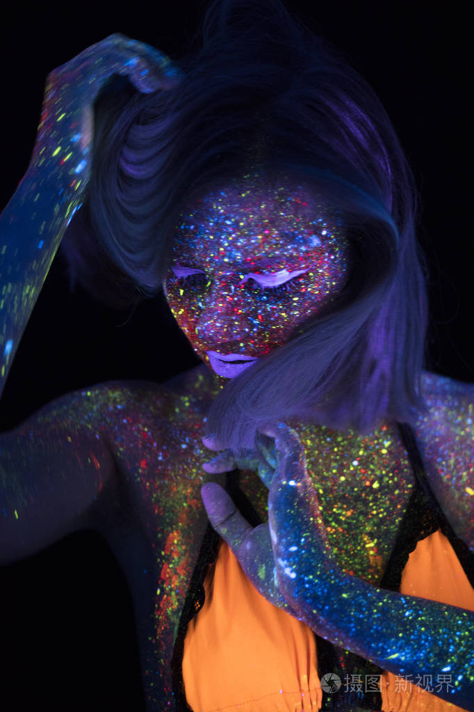 美丽的时尚女人在霓虹灯超滤光的肖像模型女孩与荧光创意迷幻化妆艺术
