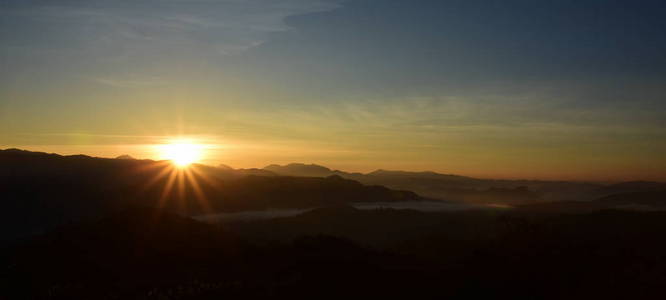 美丽的天空和金色的云彩。 日出前的山。 一大早。 太阳从山顶升起。