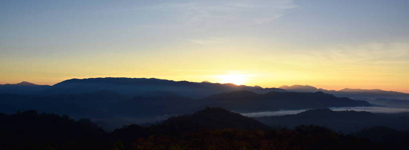 美丽的天空和金色的云彩。 日出前的山。 一大早。 太阳从山顶升起。