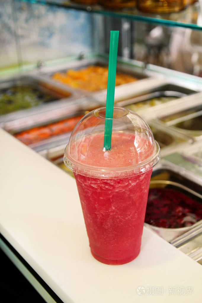 水果冰沙准备销售塑料杯与稻草。 拿走饮料的概念。 公共市场上的新鲜果汁。 各种新鲜水果和蔬菜沙拉棒健康项目。 健康的饮料。