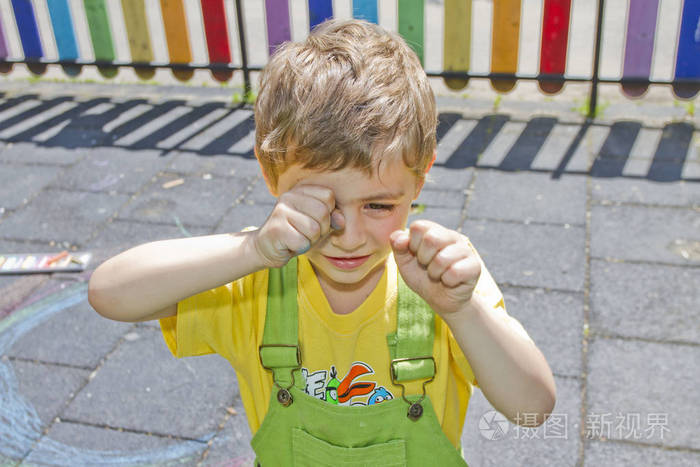 可爱的男孩哭了孩子在操场上哭一个孩子揉了揉眼睛