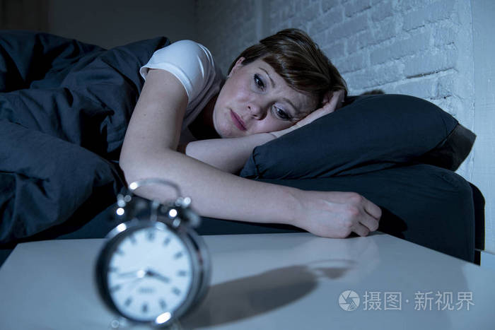 年轻迷人的红头发的白种人女人深夜躺在床上,试图睡觉,患有失眠,噩梦