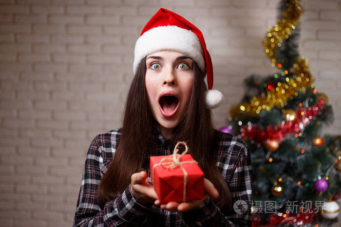 年轻可爱的惊喜兴奋的女人在圣帽是惊讶的 p