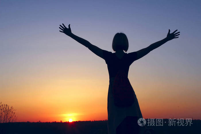 一位无忧无虑的女人在日落时在海滩上的镜头.再见阳光.