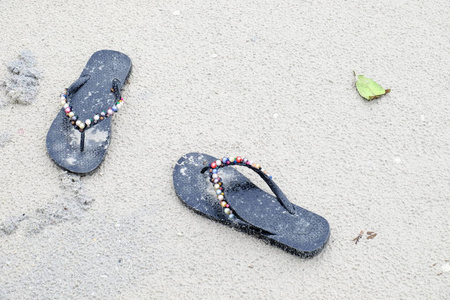  shoes are placed at the beach.The sand toys and toys are placed