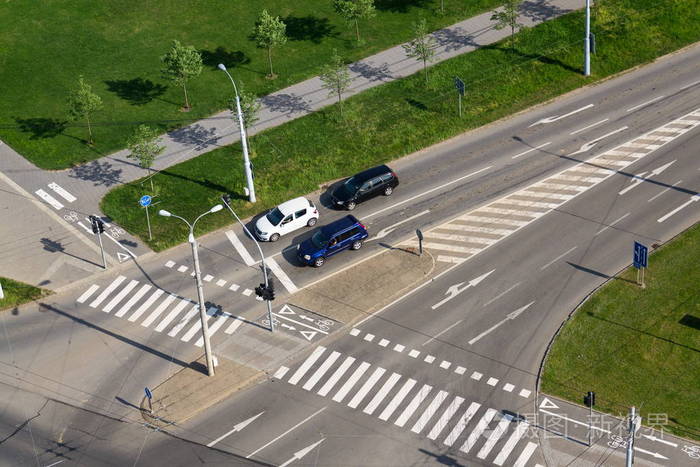 无人驾驶技术概念车在人行横道和自行车过马路前等候的汽车的鸟瞰图