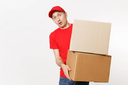 送货的年轻人穿着红色制服, 被隔离在白色背景上。男性在帽子, t恤, 牛仔裤工作作为信使或经销商持有空纸板箱。接收包。复制广告空