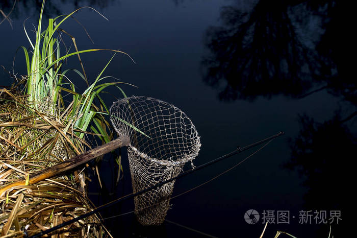 晚上在河岸上的老式渔网捕鱼的象征