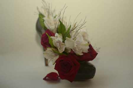 深红色的玫瑰和白色的花朵，绿色的叶子，穿着绿色的鞋跟