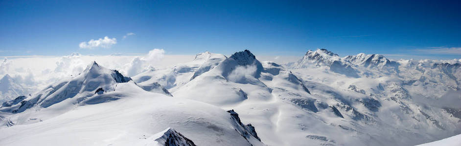 瑞士阿尔卑斯山的全景山地景观在齐马特附近，在一个美丽的一天，在一个蓝色的天空下，深冬