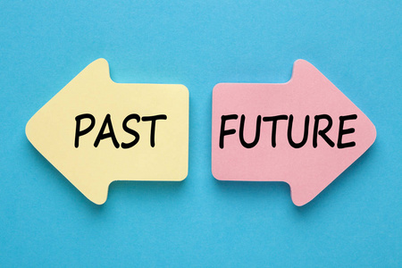 过去和未来写在蓝色背景上的纸箭头上. 商业概念. 上面的风景.照片