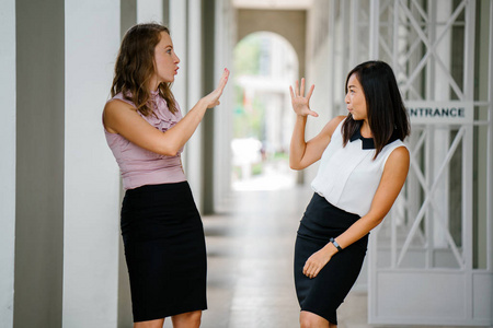 一位中国亚洲妇女和高加索白人妇女的肖像。 他们都微笑着，穿着专业。