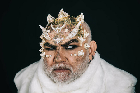 恶魔有金色的爬行动物皮肤和胡须,穿着白色的毛皮特写.