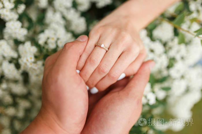 男人把订婚戒指给他的女朋友在花园里牵着她的手男友在花园里用订婚