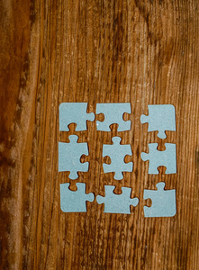 木制背景上的拼图块。连接人的概念