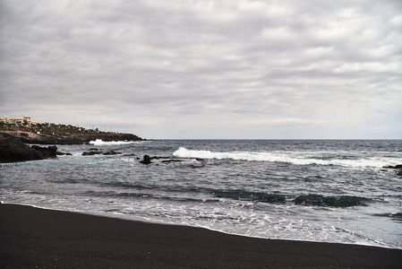 s time to sunbathe. Empty resort area. Volcanic rock near the wa