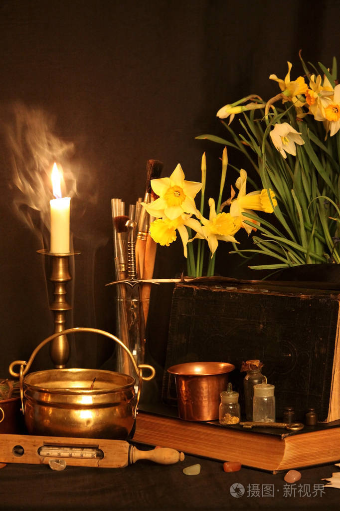 还活着:旧的油灯,古董书,干燥的玫瑰花蕾,一支燃烧的蜡烛,在铜碗药瓶