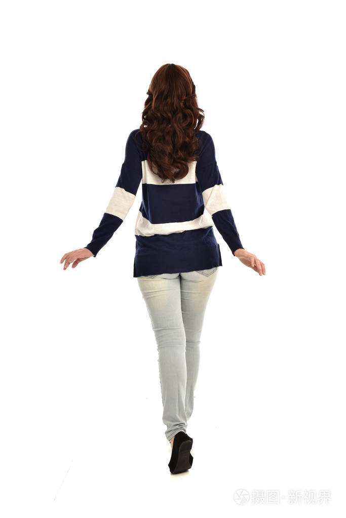 穿牛仔裤和休闲衫的女孩的全长肖像站立姿势孤立在白色工作室背景上