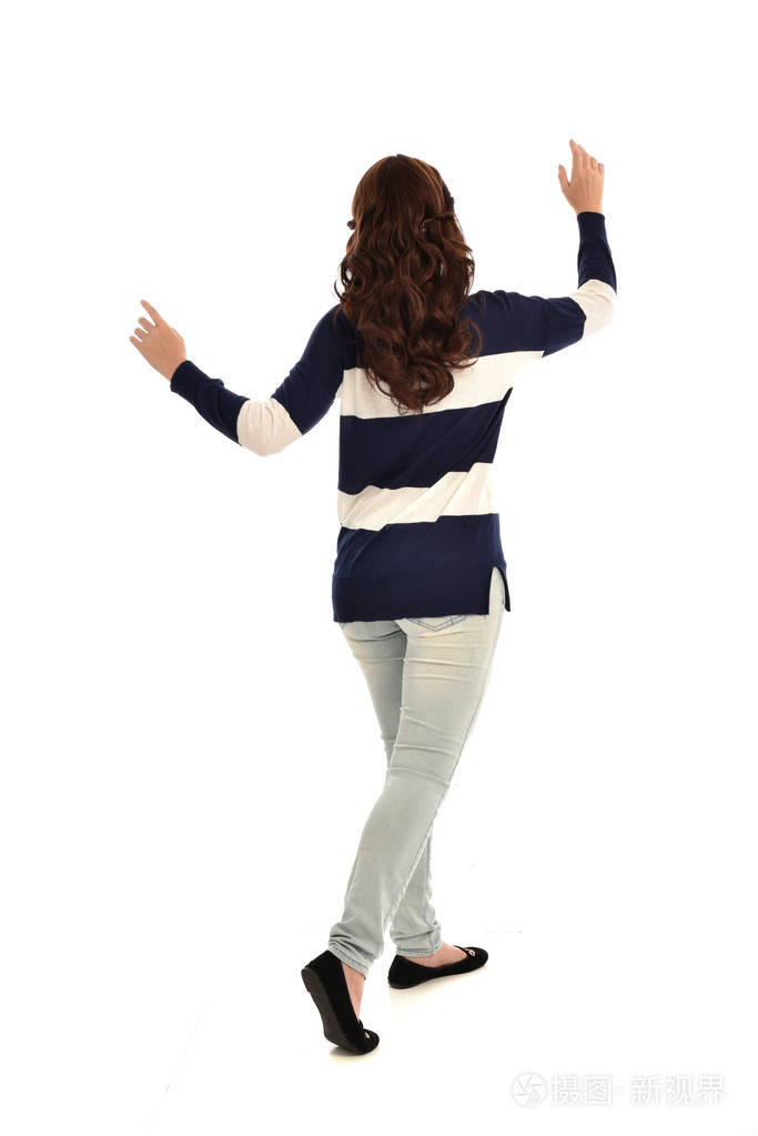 穿牛仔裤和休闲衫的女孩的全长肖像站立姿势孤立在白色工作室背景上